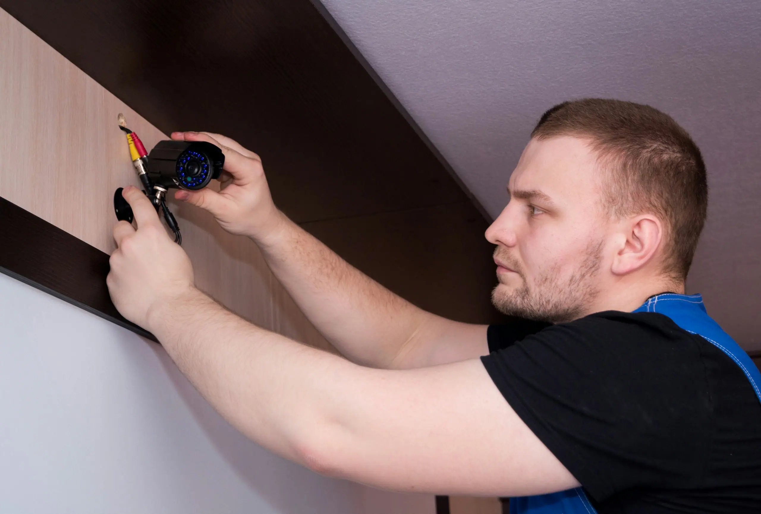 Techniker montiert ein Gerät mit dem Schraubendreher an der Wand