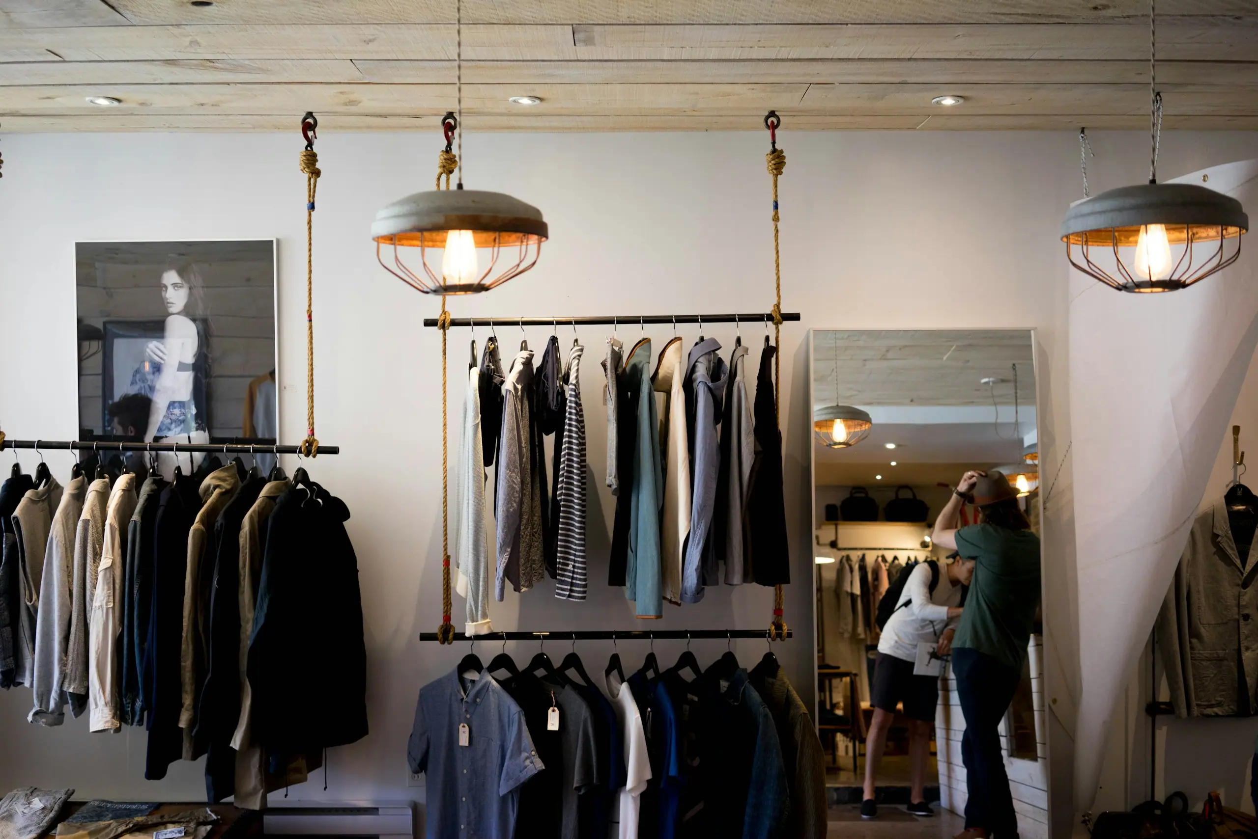 Ladenfläche einer Boutique mit hängender Ware und Pendelleuchten